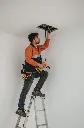 Lucid_Realism_Tcnico_de_mantenimiento_sobre_escalera_de_tijera_1.webp
